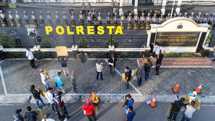 tuntut kejelasan kepada polisi massa aksi bentangkan poster di depan Mapolresta Cilacap