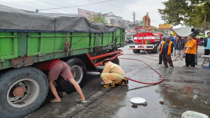 Petugas Damkar Cilacap tengah melakukan upaya pendinginan truk tronton di Kroya