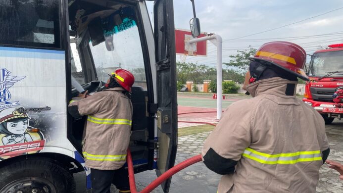 petugas Damkar Cilacap saat sedang melakukan pendinginan Bus terbakar