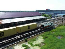 Di tengah upaya pemerintah memperkuat sistem logistik nasional, Stasiun Belawan mengukuhkan posisinya sebagai titik krusial (interaktor) yang menjembatani angkutan rel dengan gerbang ekspor-impor laut. Integrasi ini bukan sekadar soal pemindahan barang, melainkan upaya menciptakan efisiensi waktu dan biaya yang kompetitif. Stasiun yang berada di bawah pengelolaan PT Kereta Api Indonesia (Persero) Divisi Regional I Sumatera Utara tersebut memegang peranan krusial sebagai urat nadi distribusi komoditas unggulan Sumatera Utara menuju pasar global. Di stasiun tersebut merupakan lokasi tujuan akhir kereta api yang mengangkut beberapa komoditi seperti CPO (Crude Palm Oil), lateks dan petikemas sebelum dikirim ke luar Sumut dengan angkutan laut. “Setiap harinya Stasiun Belawan melayani rata-rata 22 perjalanan kereta api barang yang datang dan berangkat menuju berbagai wilayah,” ungkap Plt. Manager Humas KAI Divre I Sumatera Utara Anwar Yuli Prastyo. Sebagai stasiun muara bagi kereta api barang selama tahun 2025, Stasiun Belawan telah melayani sebanyak 83.760 ton CPO, 151.235 ton petikemas, dan 3.051 ton lateks yang dibawa dari berbagai wilayah sentra produksi, mulai dari Rantau Prapat, Asahan, hingga Lubuk Pakam dan sekitarnya, yang nantinya akan menjadi komoditas pemanfaatan eksport dan lokal. “Sedangkan petikemas yang berhasil dimuat dan didistribusikan dari Stasiun Belaawan pada 2025 sejumlah 73.593 ton,” jelasnya. Dalam operasionalnya, stasiun ini terdapat fasilitas mesin bongkar untuk komoditi CPO dan juga lateks. Selain itu juga terdapat layanan pemuatan dan pembongkaran petikemas menggunakan alat berat seperti Reach Stacker (RS). Lokasinya Stasiun Belawan yang berada di kawasan pesisir dengan ketinggian hanya +1,90 meter di atas permukaan laut (mdpl), membuat area stasiun menjadi langganan banjir rob (genangan akibat air laut pasang) yang kerap menggenangi kawasan tersebut sebulan sekali pada saat posisi bulan purnama. “Meskipun jalur sering tergenang air rob karena lokasinya yang berada di pesisir, KAI Divre I Sumatera Utara memastikan operasional perjalanan kereta api sama sekali tidak terganggu,” ujarnya. Ketangguhan infrastruktur di stasiun ini terbukti dengan tetap lancarnya pelayanan angkutan barang meski di tengah genangan air. Petugas yang disiagakan memastikan jalur kereta api tetap aman untuk dilalui agar distribusi komoditas tetap berjalan sesuai jadwal dan program yang telah ditentukan. Keberadaan stasiun ini membuktikan bahwa tantangan alam bukan menjadi penghalang bagi kelancaran perjalanan kereta api dalam membangun perekonomian di Sumatera Utara. Melalui pemeliharaan yang konsisten serta kekuatan dalam kerja sama yang sinergis. “KAI Divre I Sumatera Utara berkomitmen penuh menjaga keandalan Stasiun Belawan agar aliran barang antara kereta dan kapal laut selalu lancar dan tepat waktu. Dengan memastikan Stasiun Belawan beroperasi maksimal, KAI ikut menjaga urat nadi perdagangan tetap berlangsung guna mendorong perekonomian Sumatera Utara yang lebih maju untuk seluruh lapisan masyarakat,” pungkas Anwar. Press Release ini juga sudah tayang di VRITIMES