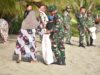 Satgas Pamtas RI–Malaysia Yonarmed 19/Bogani Bersama Warga Bersihkan Pantai Babo