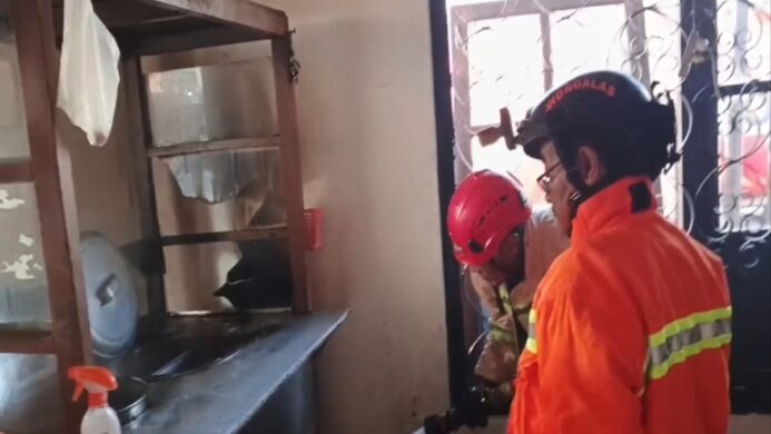 Petugas Damkar Kroya tengah melakukan pendinginan gerobak bakso yang terbakar